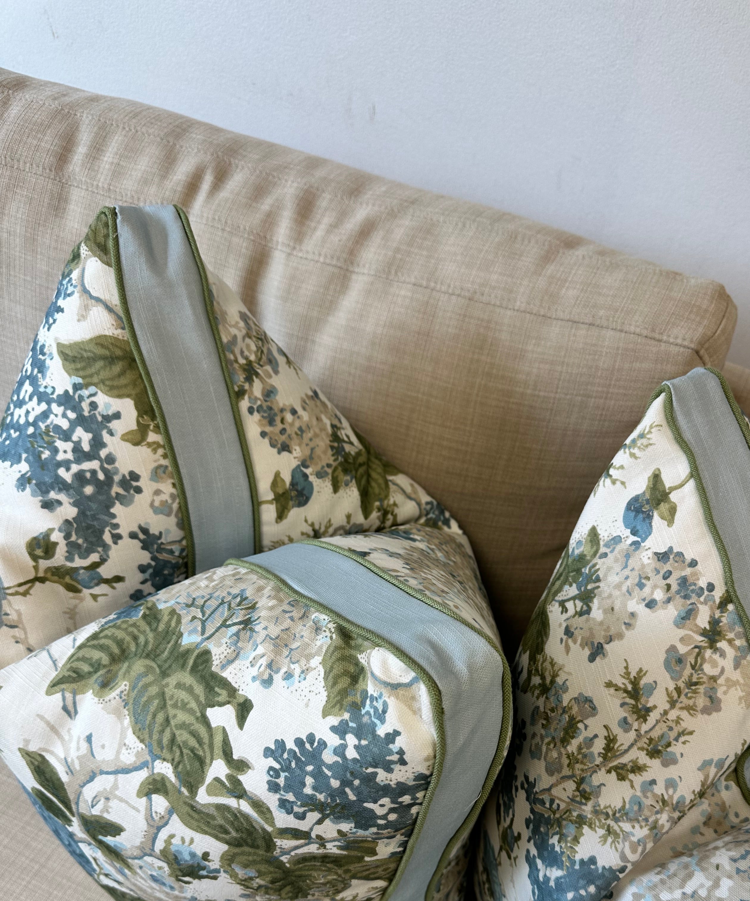 Floral-patterned pillows on a beige sofa