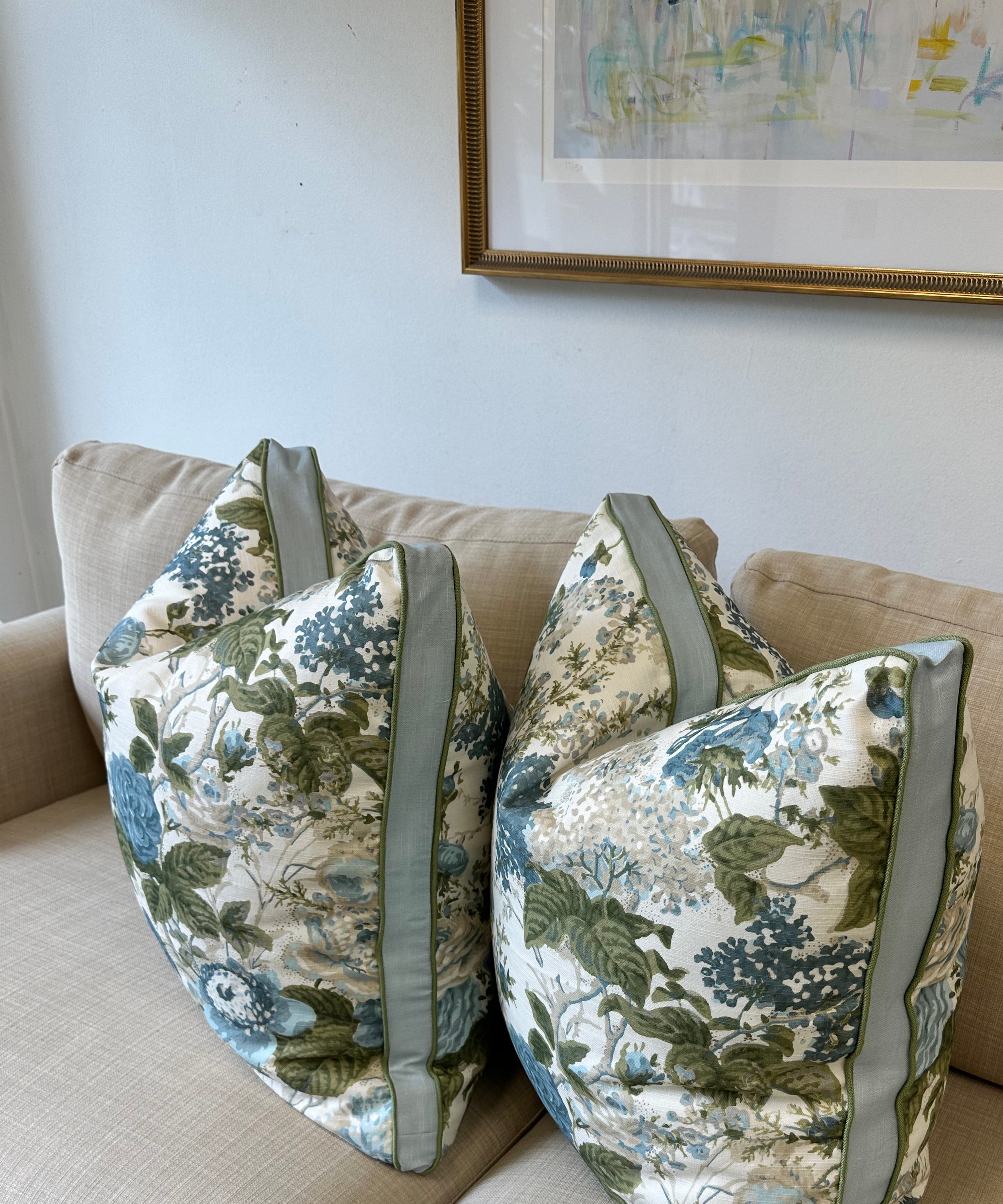 Floral-patterned pillow cover on a beige couch with a neutral wall background