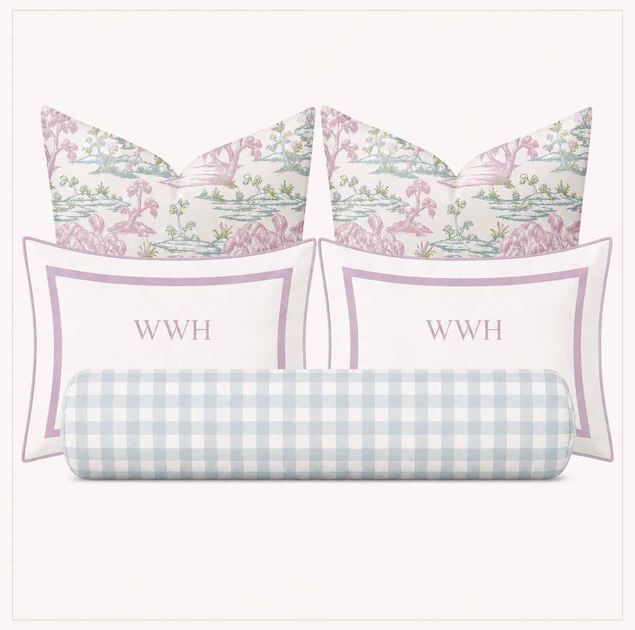 A bedding set of four pillows on a light gray background: two square pillows with a pink and green botanical toile pattern, two rectangular white pillows with a lavender border and the monogram 'WWH' in lavender, and one cylindrical lumbar pillow in a light blue and white gingham pattern.