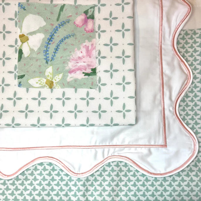 Floral patterned fabric with a scalloped edge on a matching background