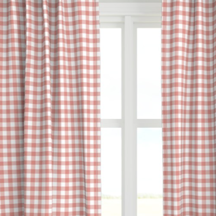 A coral colored drapery panel with a checkered pattern, displayed in a window setting.