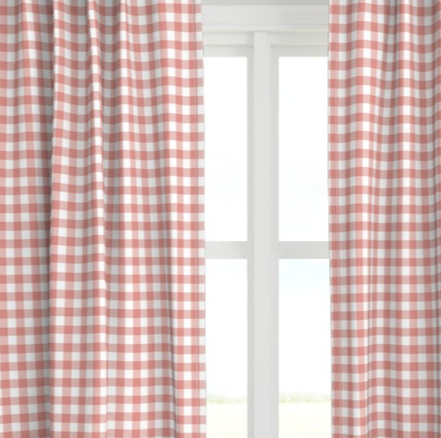 A coral colored drapery panel with a checkered pattern, displayed in a window setting.