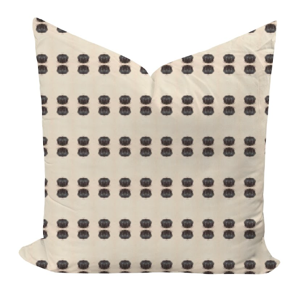 Decorative pillow with black dot pattern on beige background
