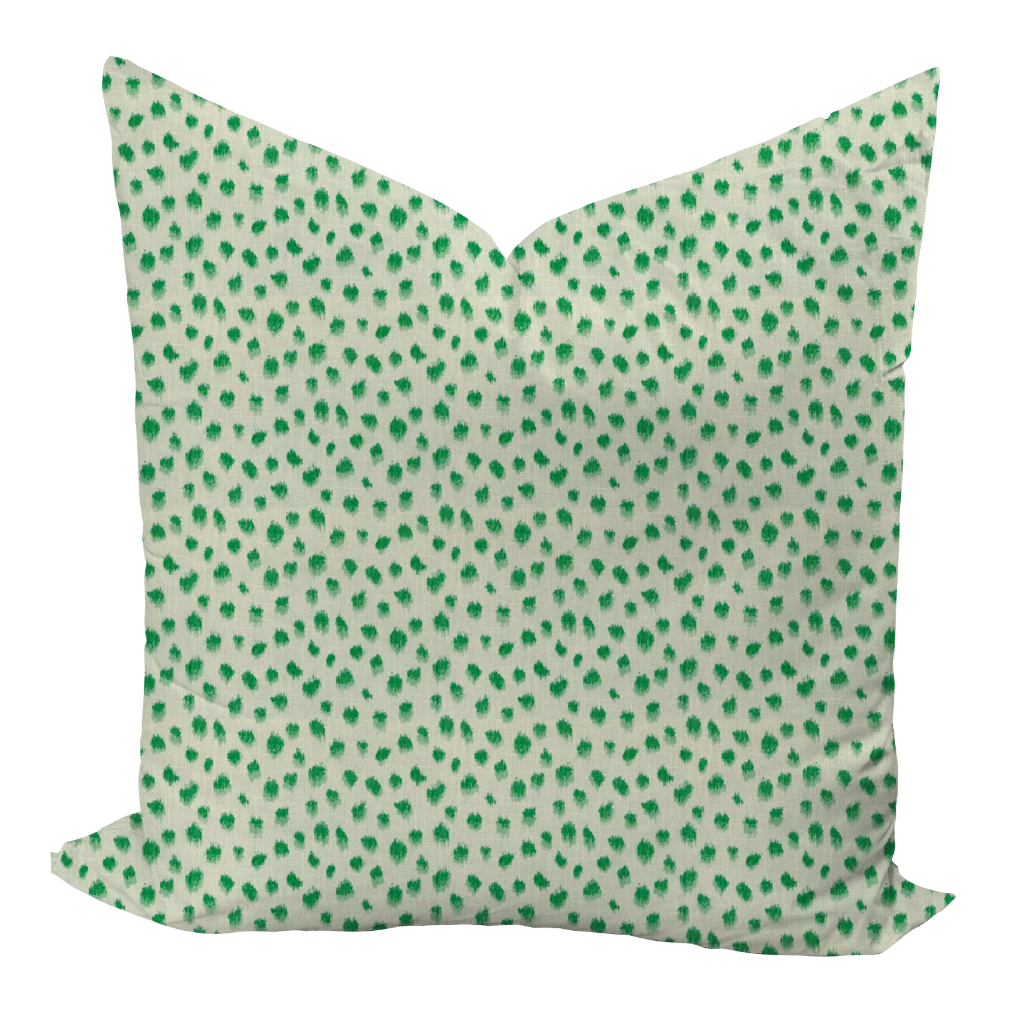 Green polka dot pillow on a white background