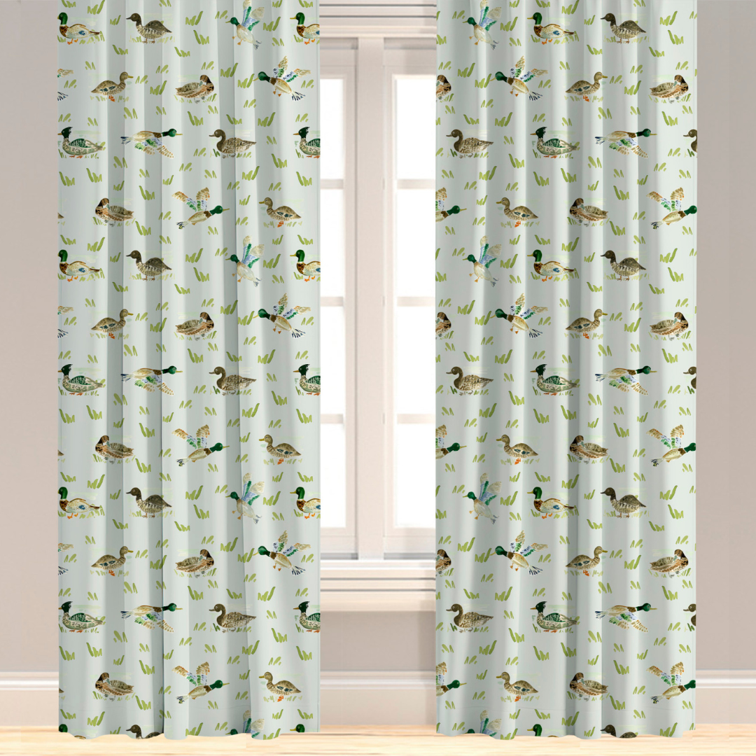 A pair of green drapery panels with a pattern of mallard ducks and leaves.