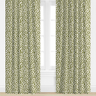 Green patterned curtains on a white window with a white wall background