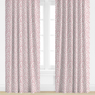 Pair of pink patterned curtains in front of a window with a white background