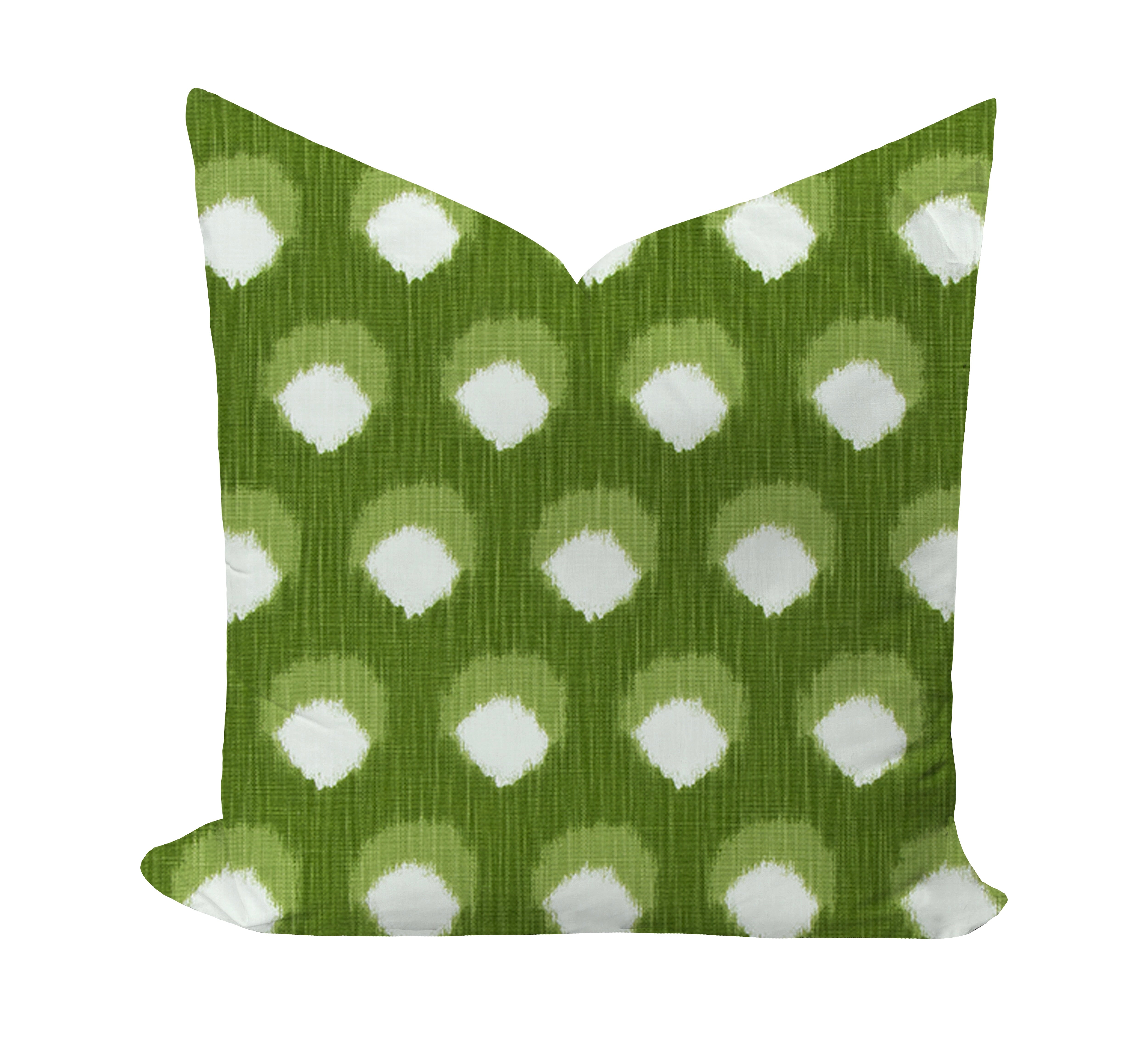 Green pillow with white polka dot pattern on a white background