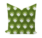 Green pillow with white polka dot pattern on a white background