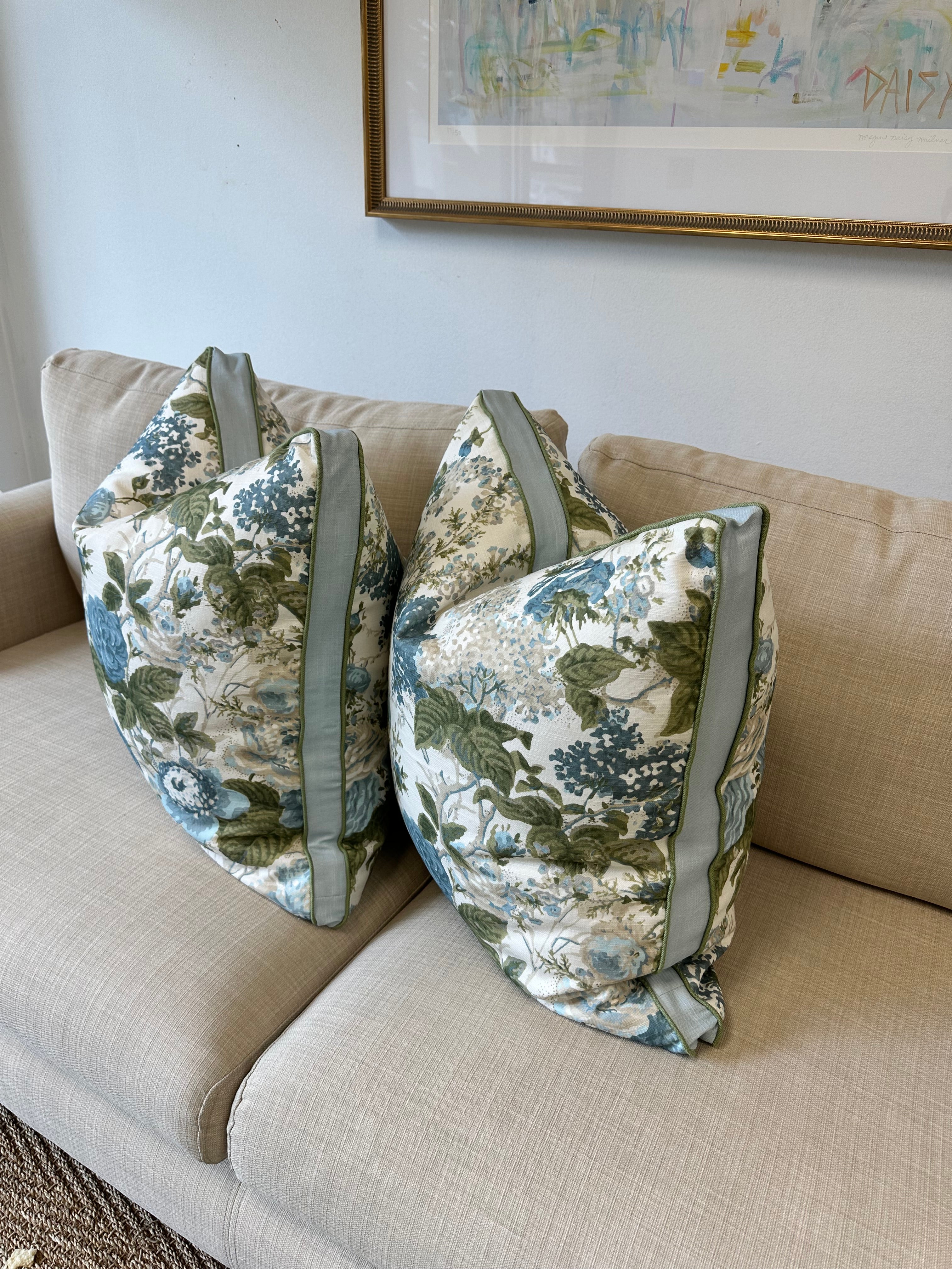 Floral-patterned pillow cover on a beige couch with a neutral wall background