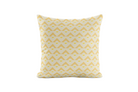 Yellow geometric patterned pillow on a light gray background