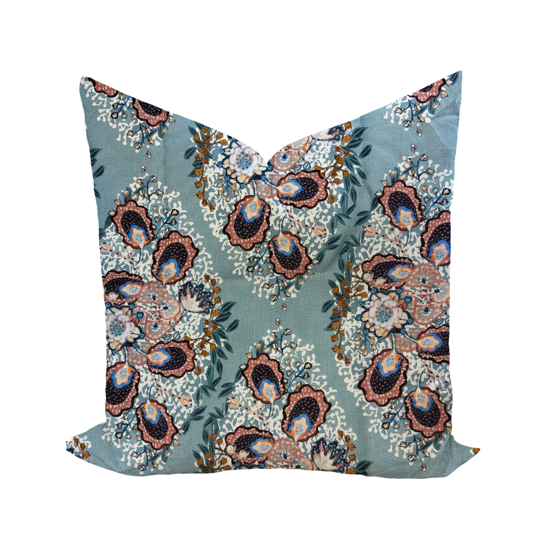 Decorative pillow cover with a floral design in a colonial blue color on a linen background, featuring a solid back.