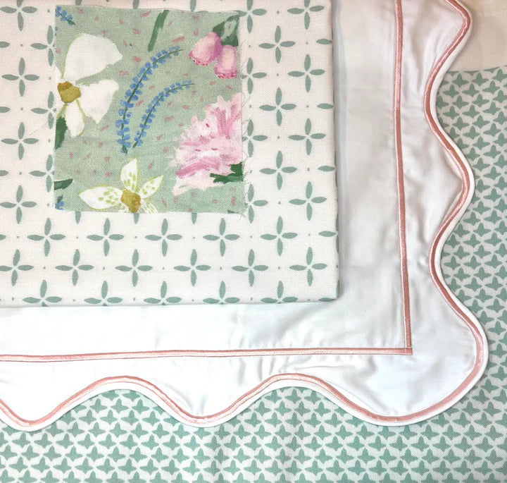 Floral patterned fabric with a scalloped edge on a matching background