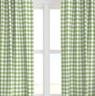 A set of green checkered drapery panels hanging on a window, with light streaming through the glass.