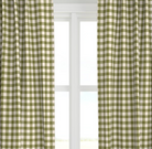 A set of green checkered drapery panels hanging on a window, with light entering through the window behind them.
