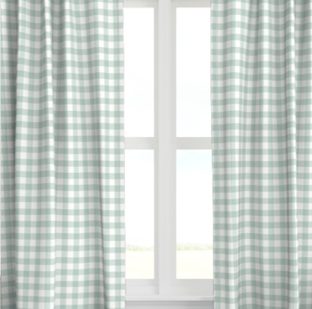 A set of seafoam green checkered drapery panels hanging on a window, with light filtering through the fabric.