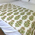 Floral patterned bed footer in pink and green on a bed with white bedding