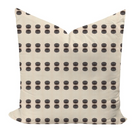 Decorative pillow with black dot pattern on beige background