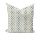 A square throw pillow with a cream background and a repeating light blue starburst geometric pattern, shown against a plain white background.