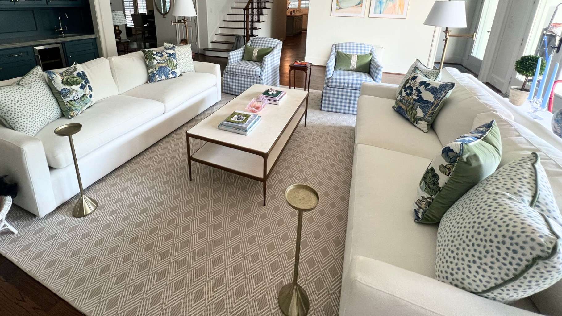 Living room with white sofas, patterned pillows, and a coffee table.