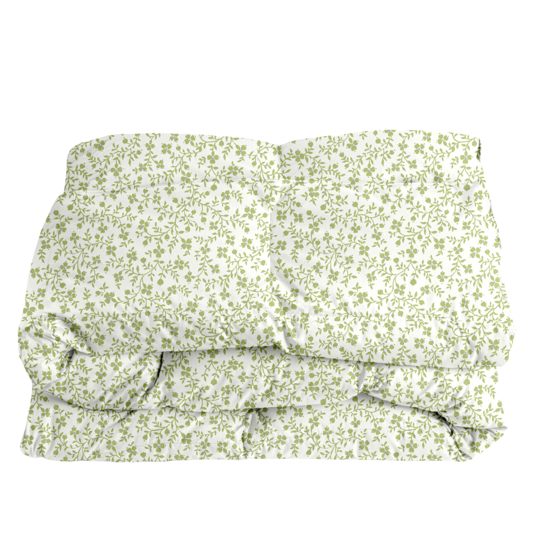 Folded floral comforter in green on a white background