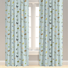 A pair of blue drapery panels with a butterfly pattern, installed on a window.