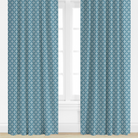 Pair of blue patterned curtains on a window with a white background