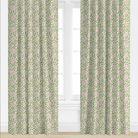 Green curtains with pink floral pattern in a room with white walls and window blinds.